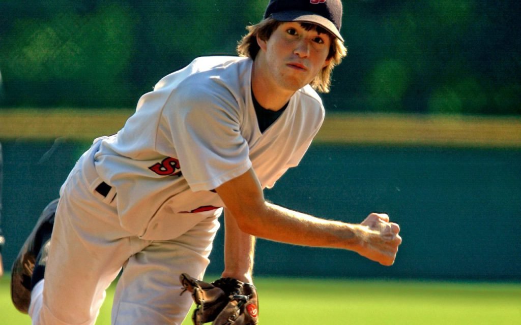 A pitcher in mid-delivery on the mound