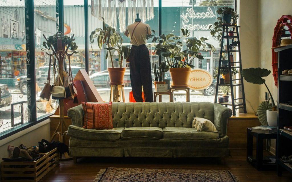 Racks of secondhand clothing in a bright thrift store