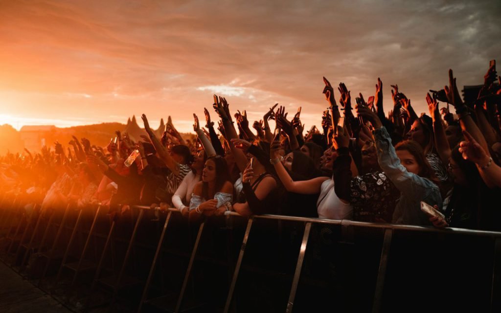 A festival crowd at golden hour seen from a distance