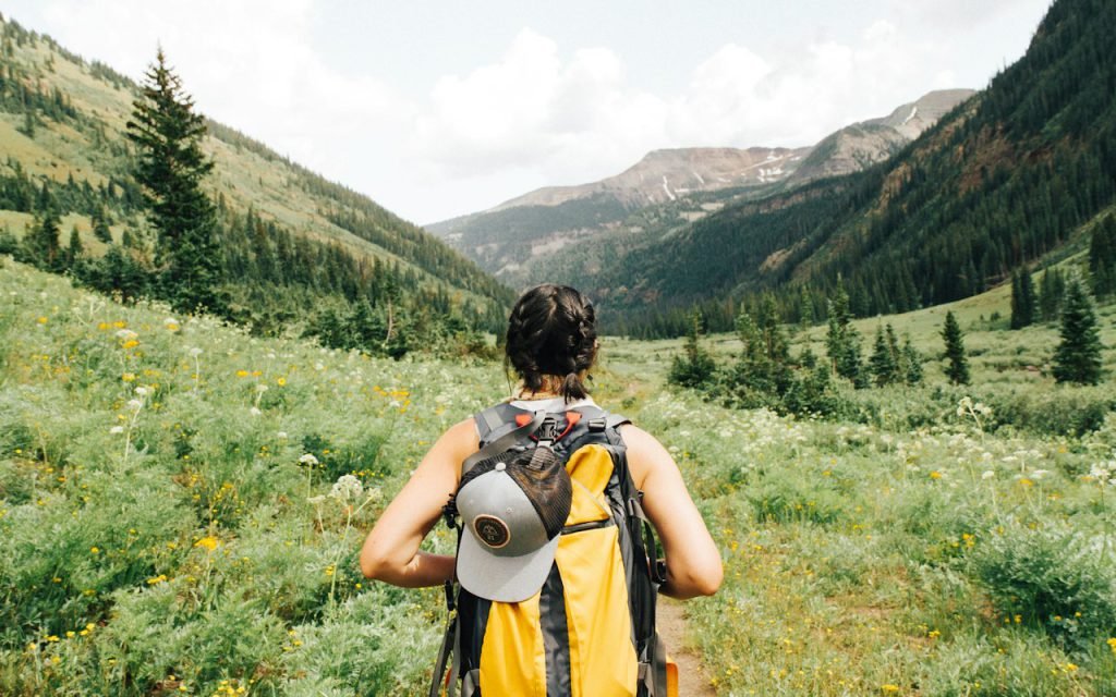 A hiker standing on a rocky trail with wide views