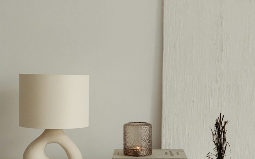 A warm lamp glowing beside a stack of books