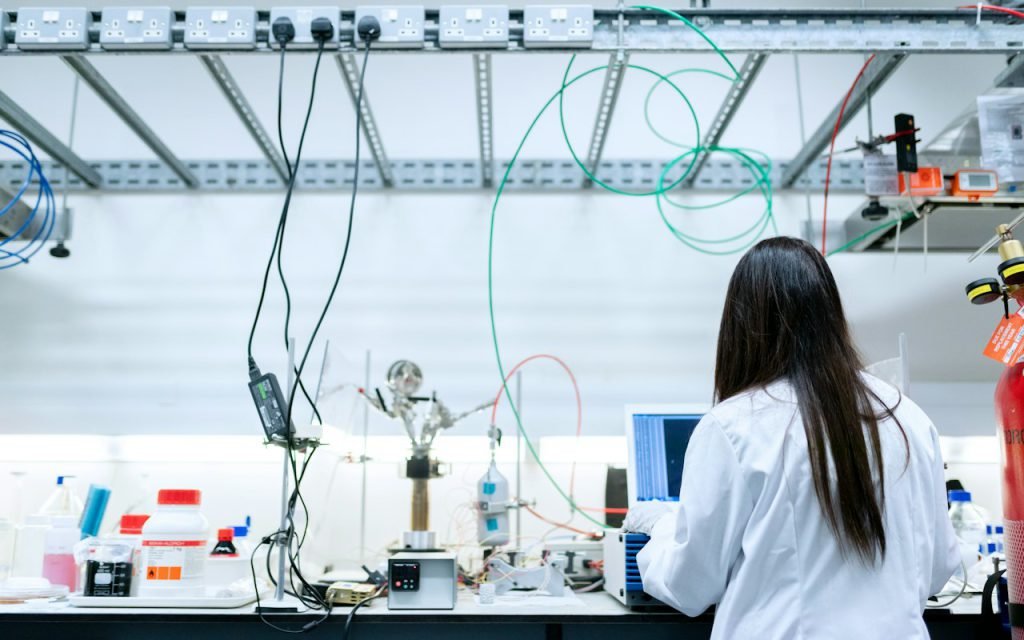A scientist in a lab coat working at a laboratory bench