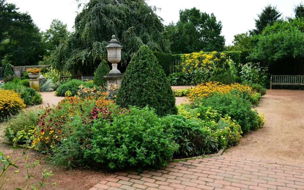 A colorful flower bed in bloom beside a green lawn