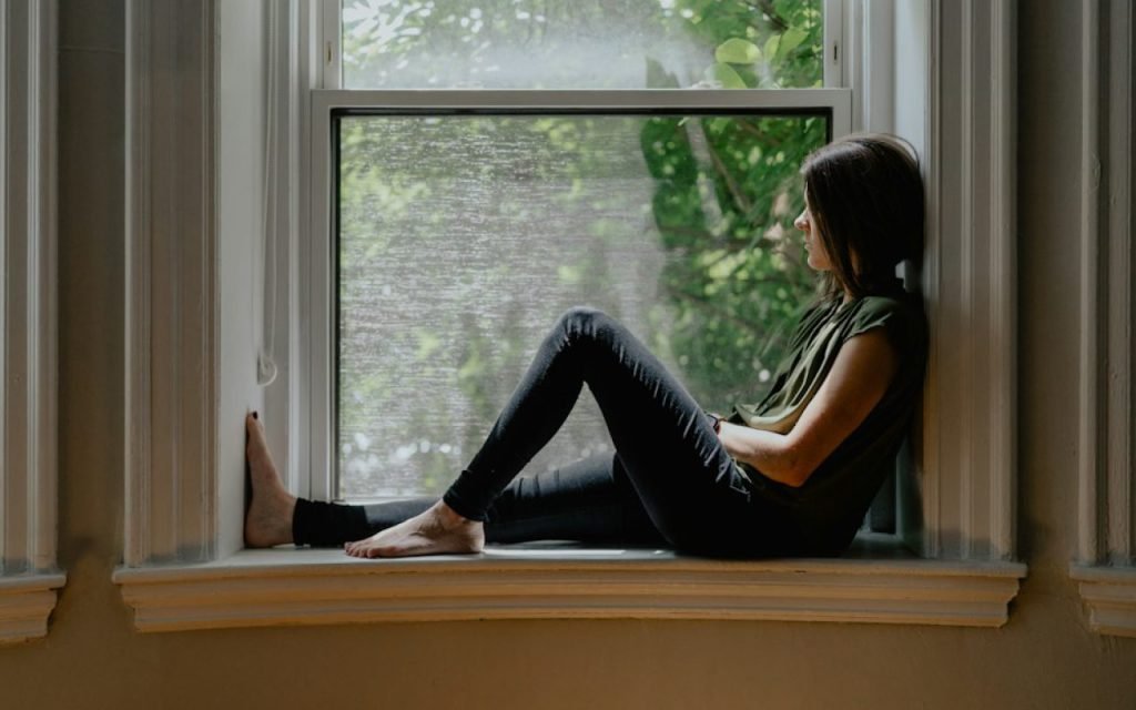Person reading a book by a bright window