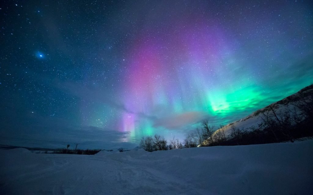 Green aurora glowing above a snowy landscape