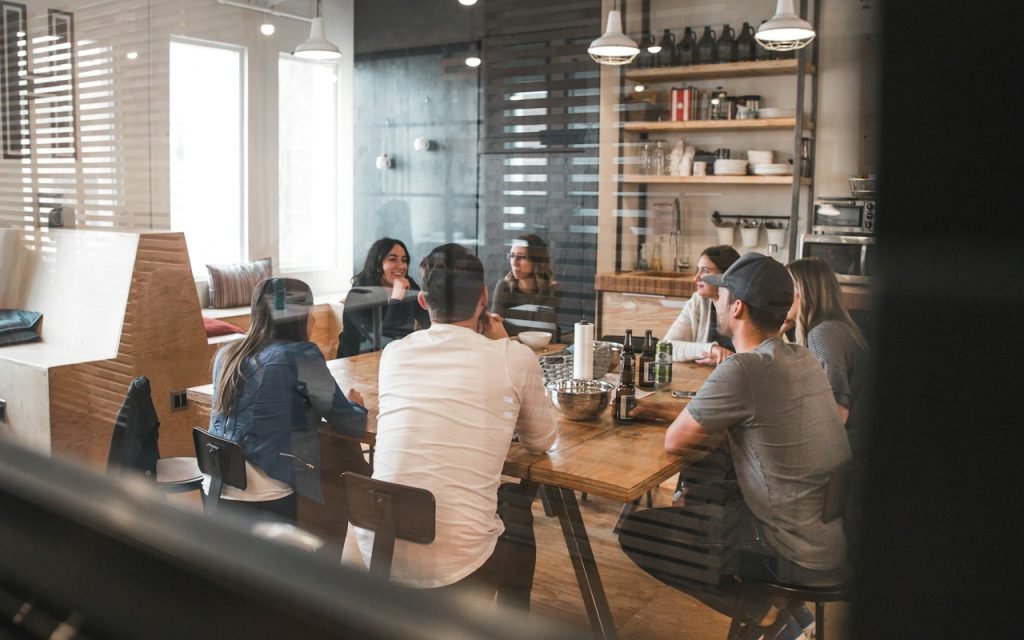 A small team meeting around a table with laptops