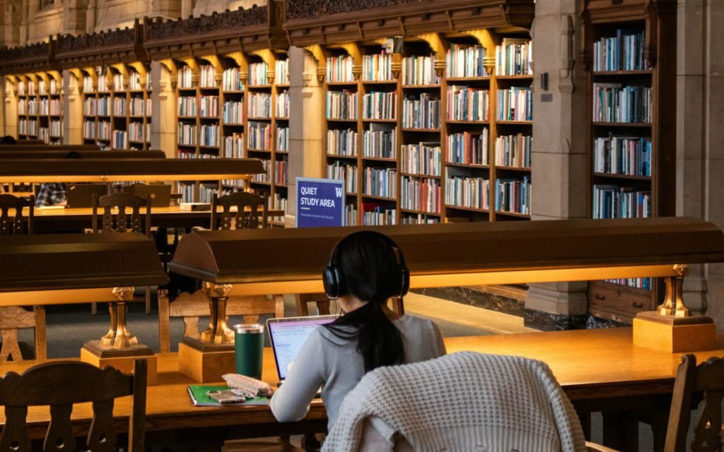 Students studying at tables in a bright library